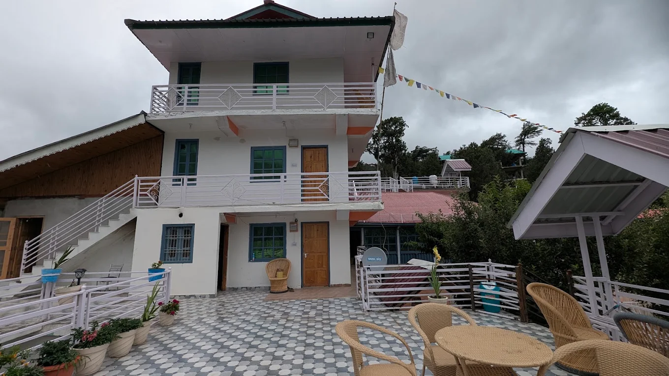 KinVatika Homestay exterior with Himalayan peaks behind